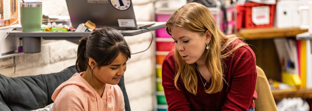 A teacher talking about a book with a student